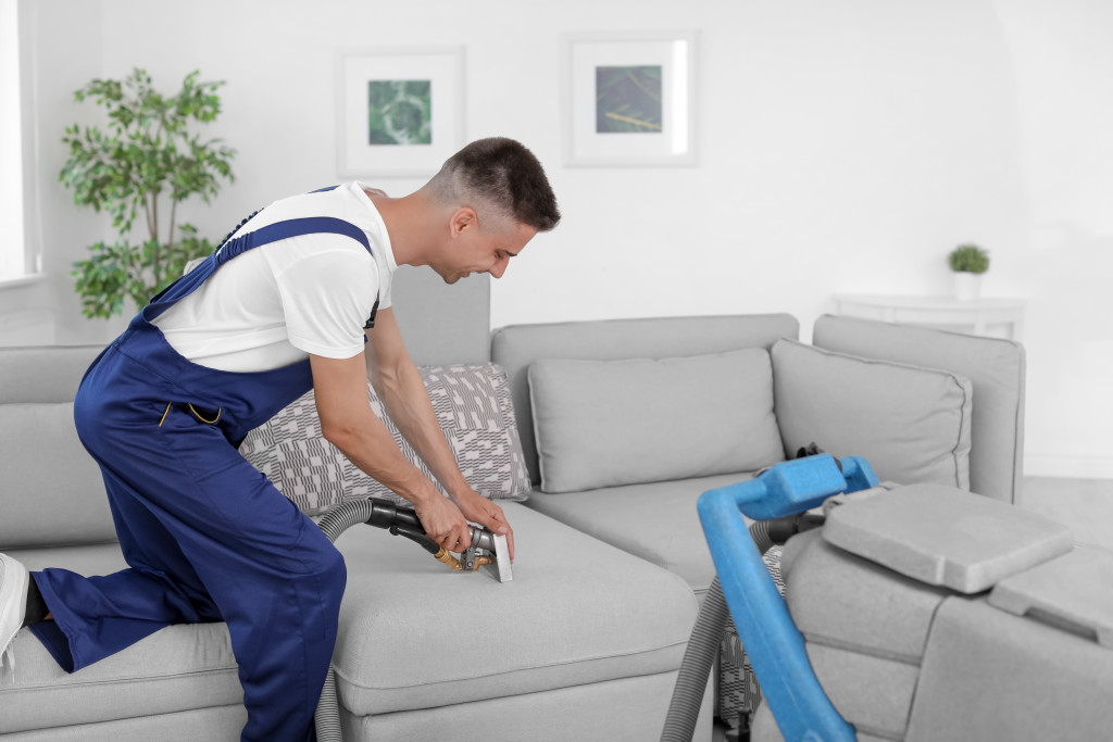 man cleaning the sofa