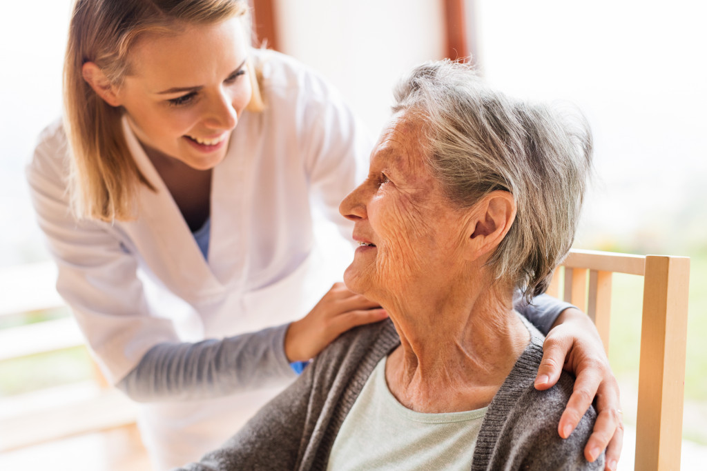 health care assistant tending to the medical needs of a senior woman