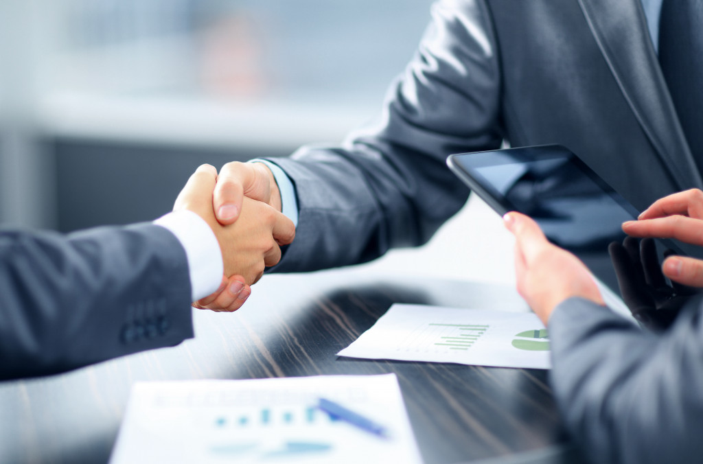 Business persons shaking hands to signify a deal.
