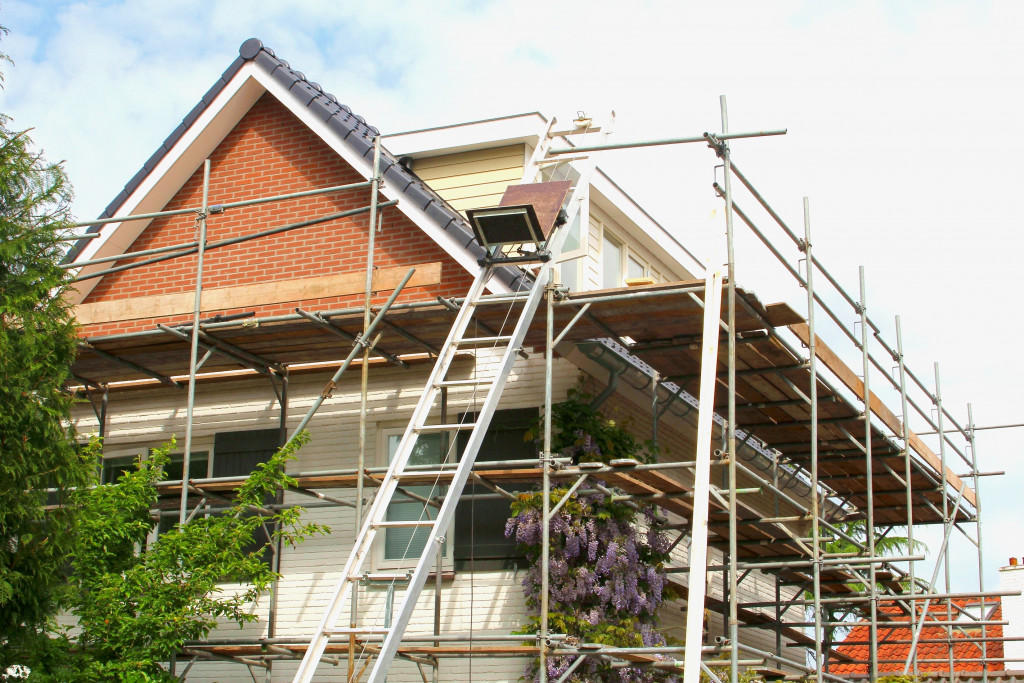 house being renovated with ladders and structures all around