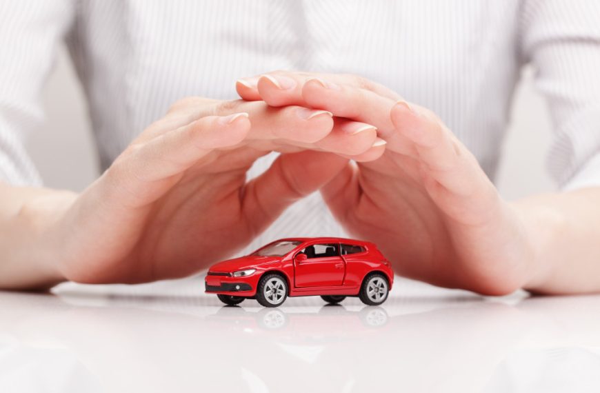 a person shielding a miniature car