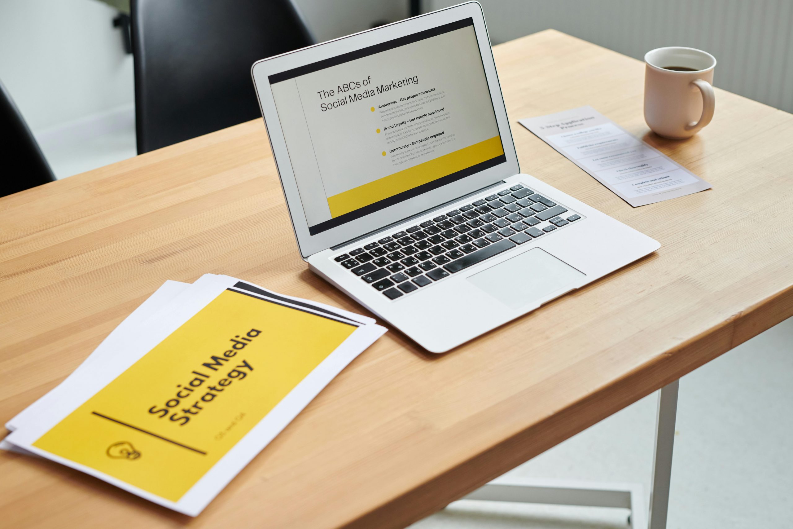 printed social media marketing strategy sheet next to a laptop on a desk