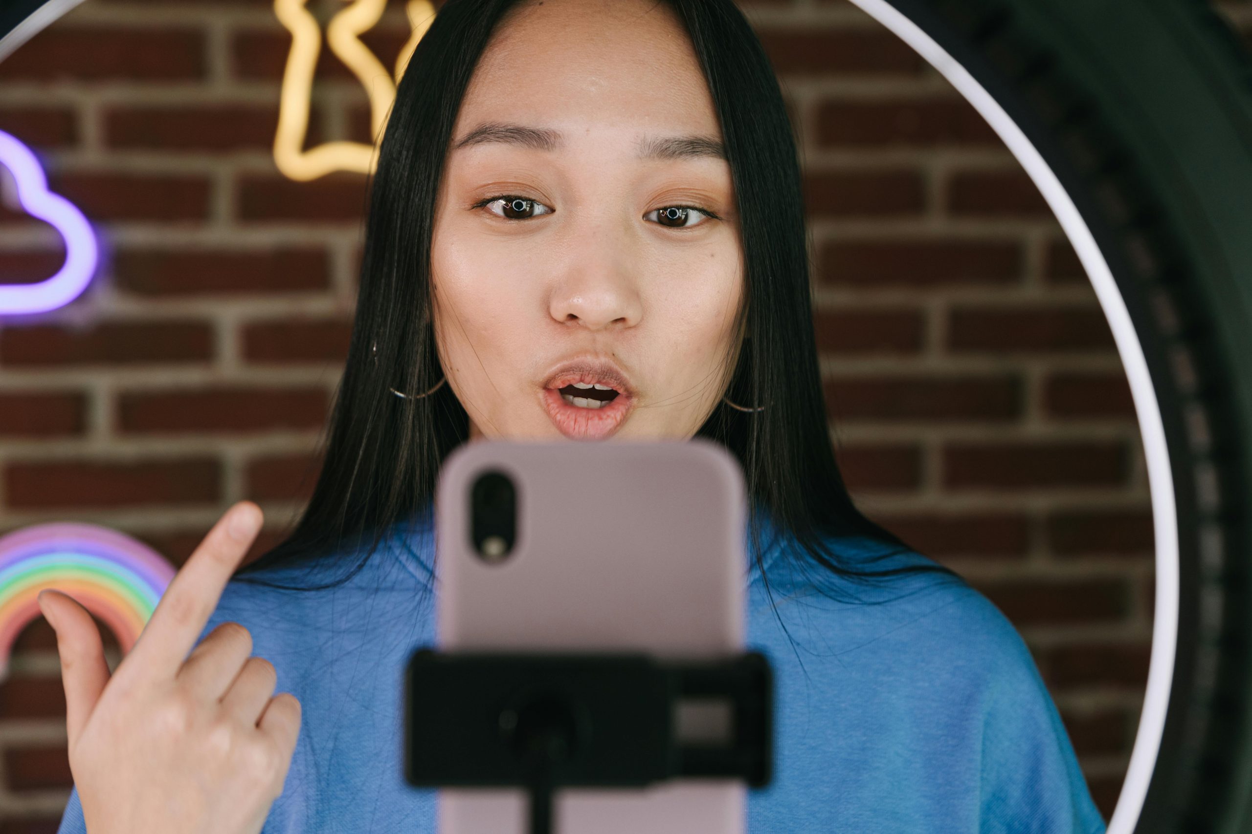 female influencer talking while filming with a smartphone mounted on a tripod